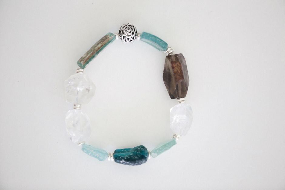Replace a Broken Crystal Bracelet — Marking a New Chapter New gemstone bead bracelet laid out on white, a replacement chosen after a protection bracelet shattered