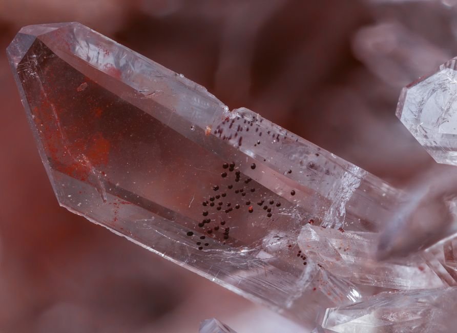 why did my crystal crack by itself — clear quartz point with visible red inclusions and internal fracture lines