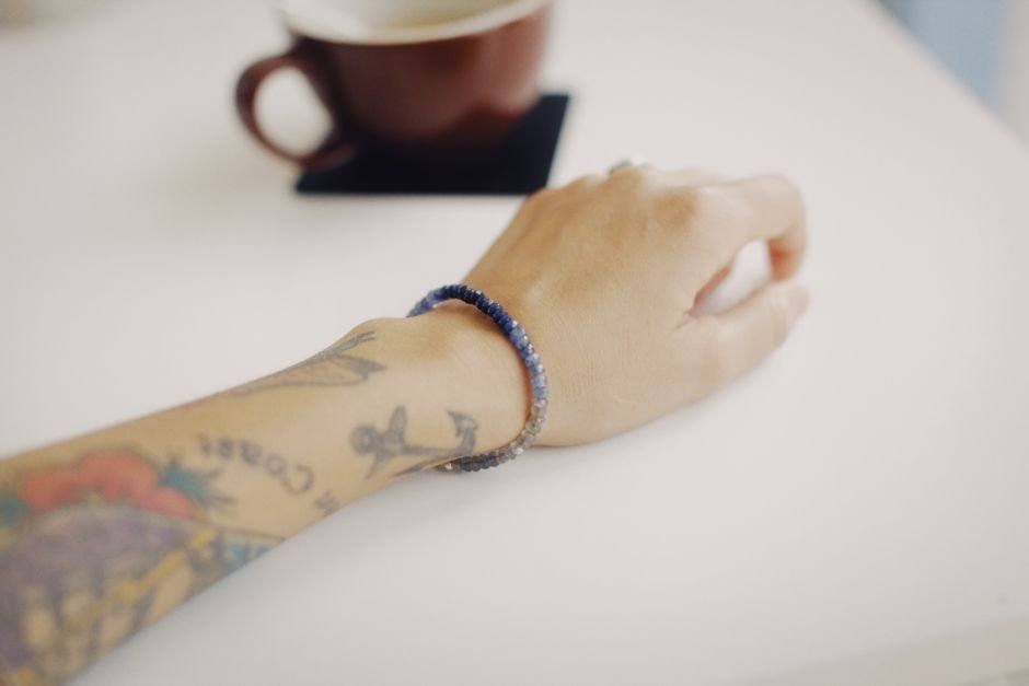 Wrist wearing a blue crystal bead bracelet during everyday activities, the daily stretching that wears out elastic cord