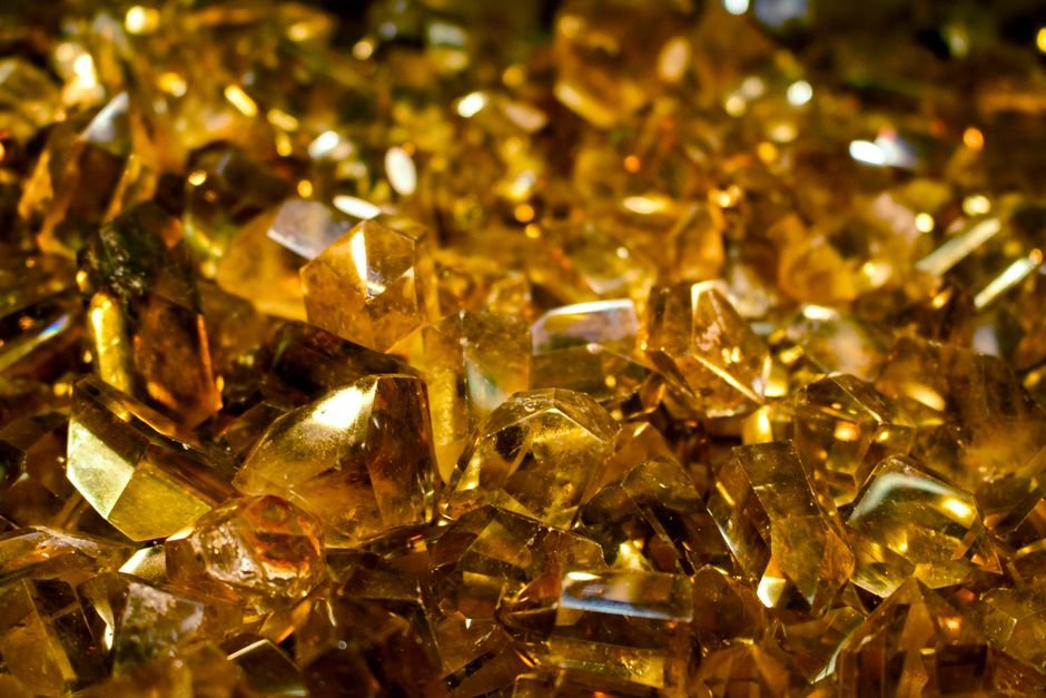 Bed of bold orange citrine crystals, the saturated color typical of the heat-treated citrine that dominates the market