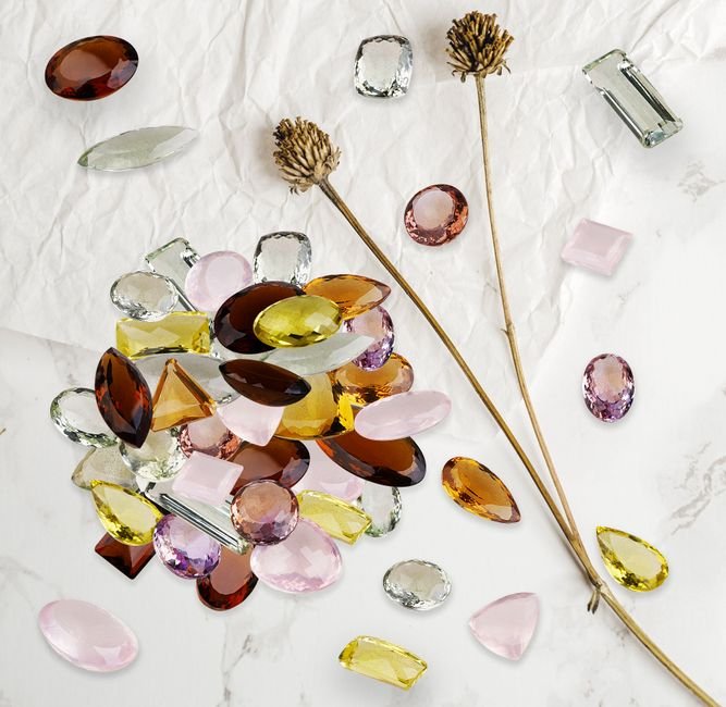 Crystal Care Mistakes — Why Jumbled Storage Damages Softer Stones Faceted gemstones piled together in a heap, a storage mistake that lets harder stones scratch softer ones