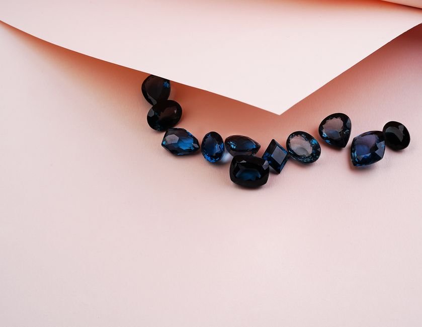 What to Do With a Fake Crystal — Keep It, Replace It, or Return It Faceted deep-blue glass gems on pink paper, the kind of piece you can keep using or replace once you know it's synthetic