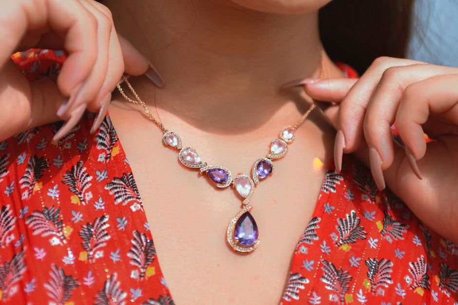 Woman wearing an amethyst crystal necklace, showing daily wear as a key factor in how fast crystals feel like they work