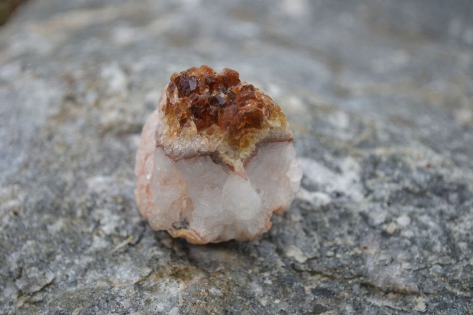 Small geode with a white quartz base and burnt-orange tips, the classic tell of heat-treated citrine