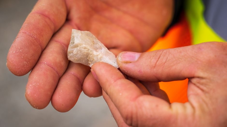 Broken Crystal Safety — Check Sharp Edges Before Handling Hands carefully holding a small sharp quartz shard by the fingertips to check its edges before gripping it