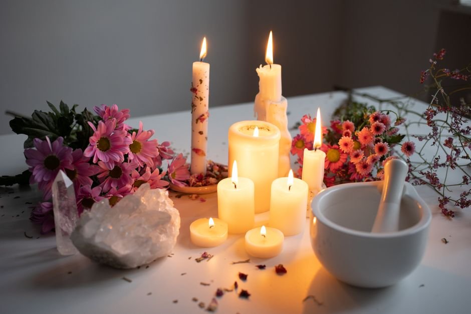 Intention Over Material — Any Focus Object Can Anchor a Ritual Candles, flowers, and a quartz cluster arranged on a ritual table, where the object anchors intention the way a candle does