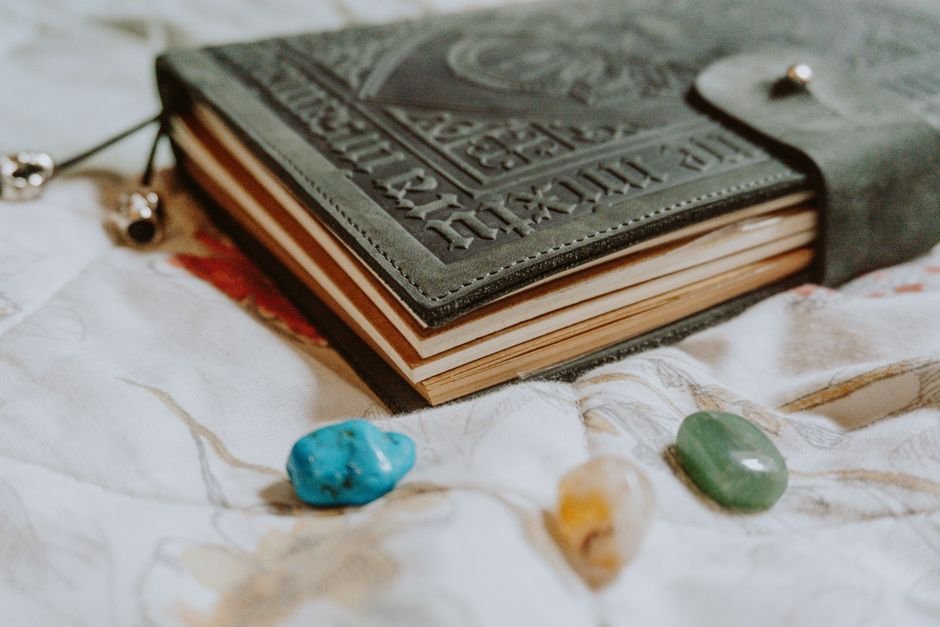 Sentimental Attachment to Crystals — Why Letting Go Feels Hard Leather keepsake journal with tumbled stones kept nearby, the sentimental attachment we form to meaningful objects