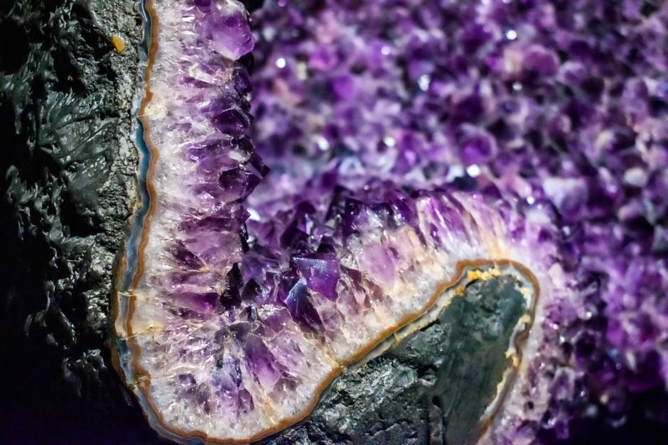Amethyst geode edge showing natural banding from deep purple to white, the color zoning dyed quartz can't replicate