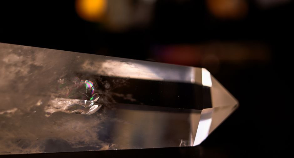 Clear quartz tower with an internal fracture creating a rainbow flash, its mineral composition unchanged by the crack