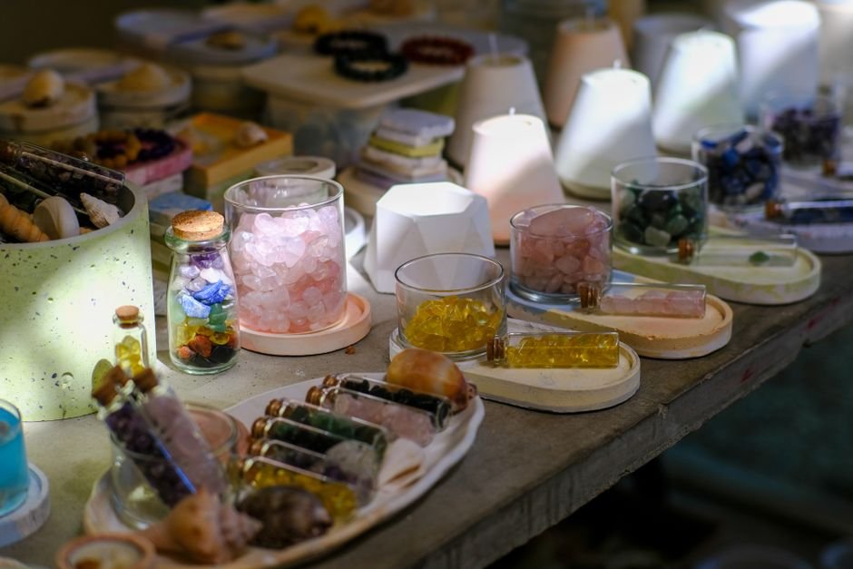 Crystal shop display with jars of rose quartz, citrine, and tumbled stones, where dyed and imitation pieces mix with genuine ones