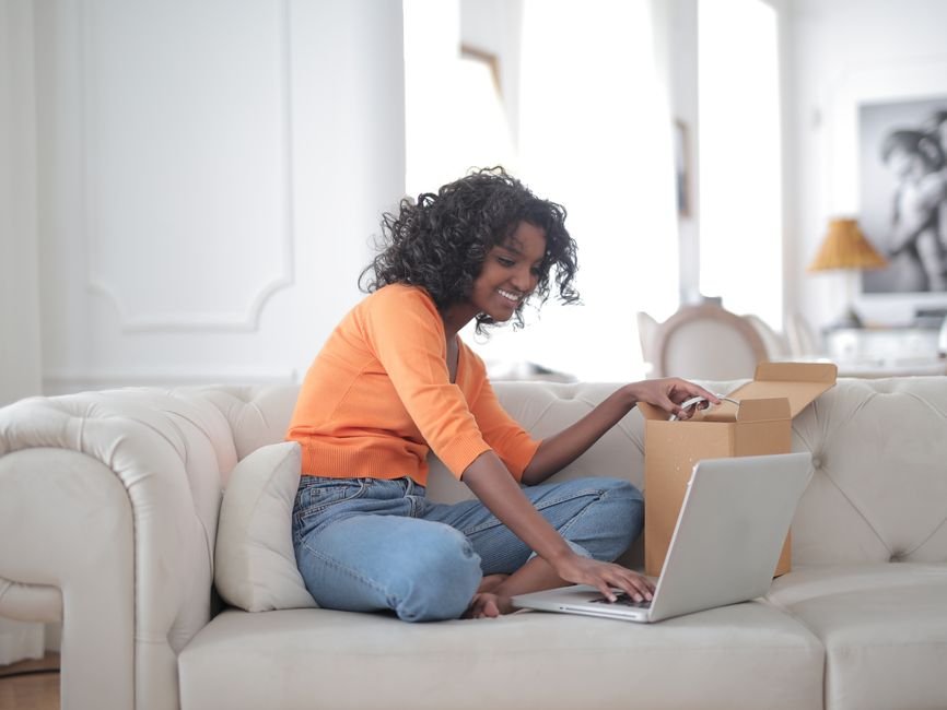 How to Vet a Crystal Seller Online — Reviews, Sourcing, and Returns Woman on a sofa vetting an online crystal seller's reviews and return policy on her laptop before ordering