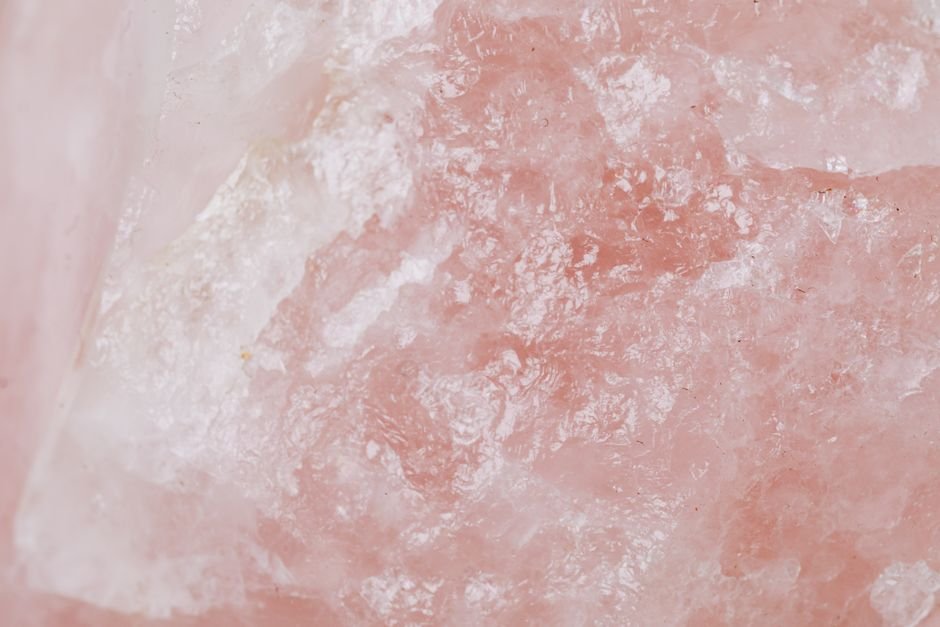 Milky rose quartz macro with hazy internal texture, caused by the microscopic fiber inclusions that create the pink color