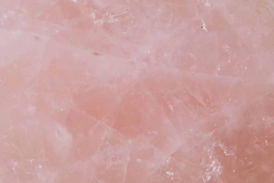 Pale muted pink rose quartz surface with faint internal lines, the soft natural color often mistaken for fake