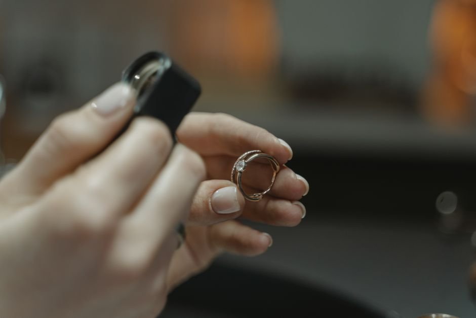 Jeweler inspecting a gemstone ring through a loupe, the most reliable way to verify a crystal's authenticity