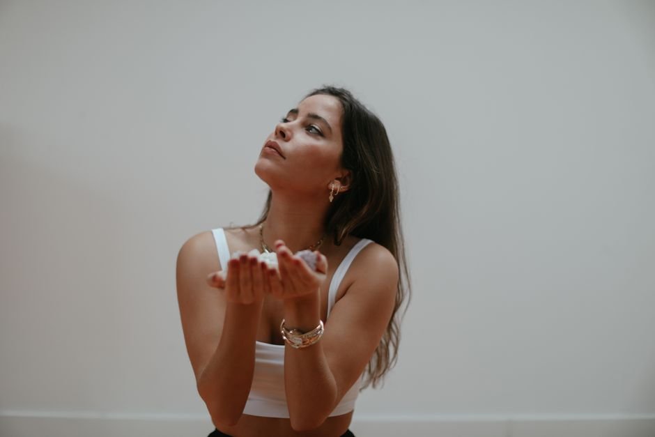 How to Activate a Crystal — Meditate With a Clear Intention Step by Step Woman meditating with cupped hands holding small crystals while focusing on a specific intention
