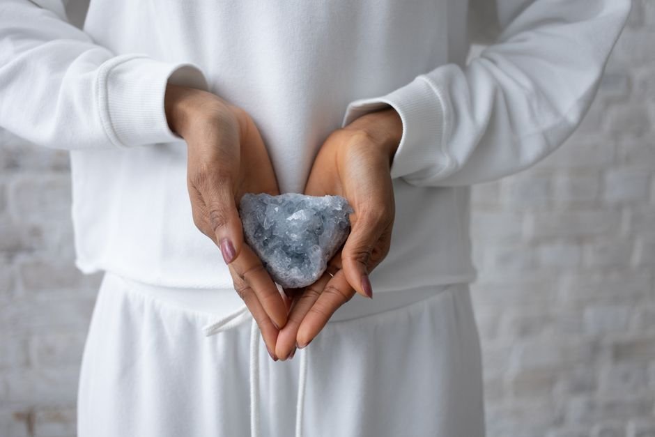 Person gently cradling a celestine crystal in both hands, showing how belief, ritual, and consistency shape the crystal experience