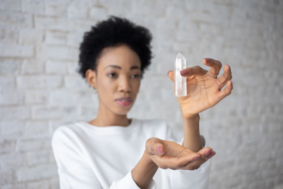 Woman examining a clear quartz point thoughtfully, asking whether the crystal or her own circumstances changed
