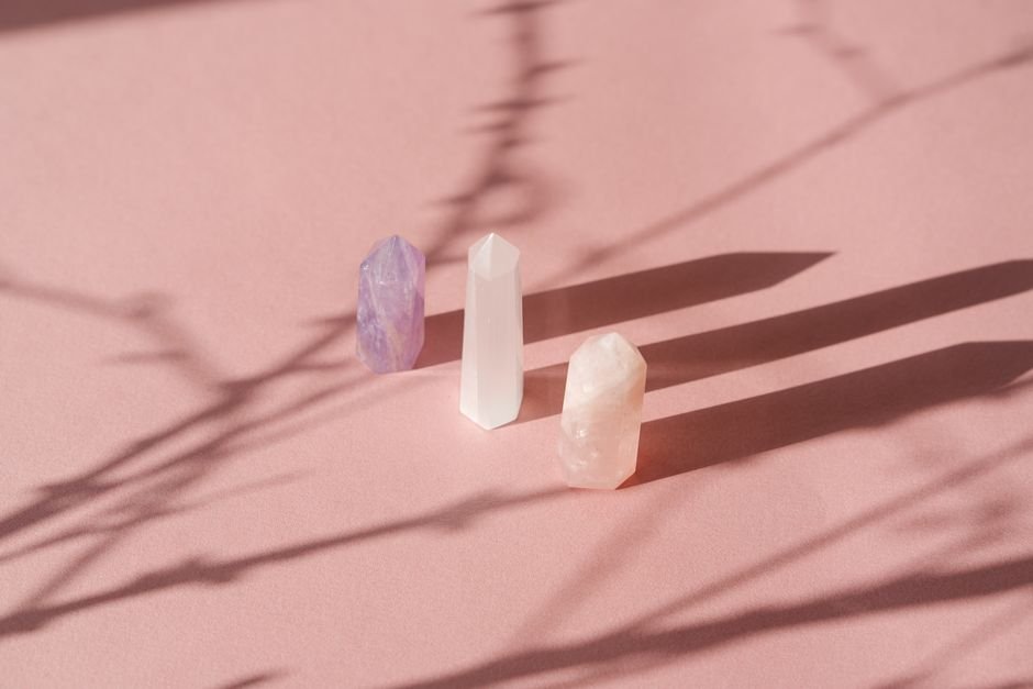 Safe Ways to Charge Crystals — Match the Method to the Stone Type Selenite, amethyst, and rose quartz towers standing in soft natural light, stones that suit different recharging methods