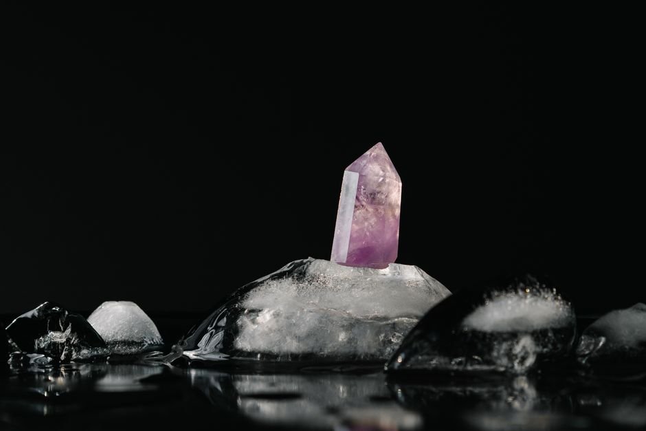 Thermal Shock in Crystals — Rapid Temperature Change Cracks Stones Amethyst crystal point standing on melting ice against a black background, showing the hot-and-cold stress behind thermal shock