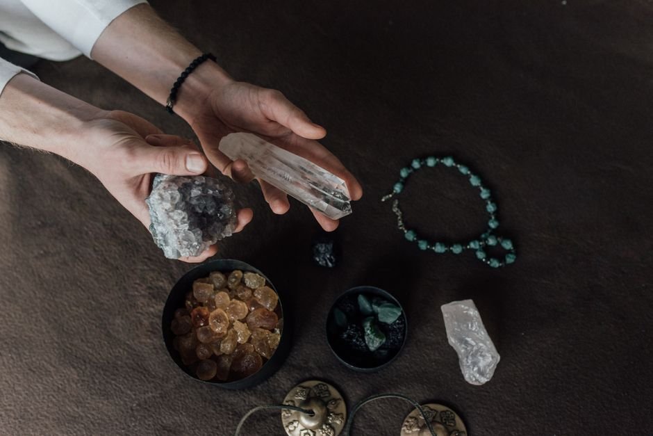 Hands holding a clear quartz point and a raw crystal cluster, checking the most common reasons a crystal is not working