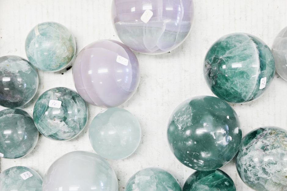 Buying Authentic Crystals — An Oversaturated Market With No Certification Polished fluorite spheres with price stickers in bulk retail stock, the crowded market that makes vetting sellers essential