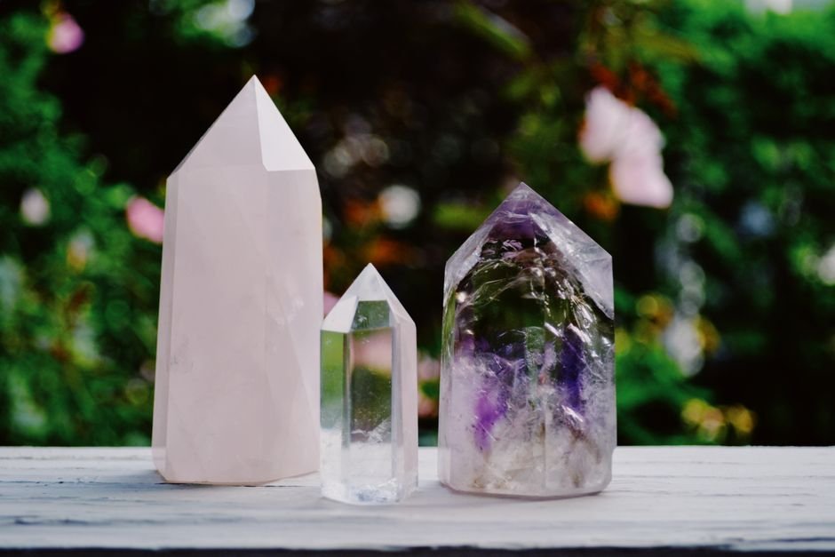 Crystals including amethyst arranged outdoors in open daylight, the sun-charging habit that fades purple stones fastest