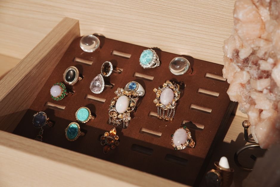 Gemstone rings and a crystal specimen stored in a closed jewellery box, the storage that prevents UV fading