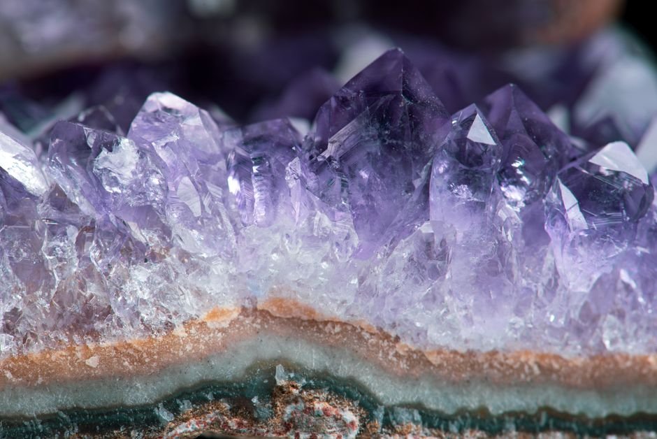 Deeply saturated natural amethyst formations, showing the uneven colour distribution that dyed quartz lacks
