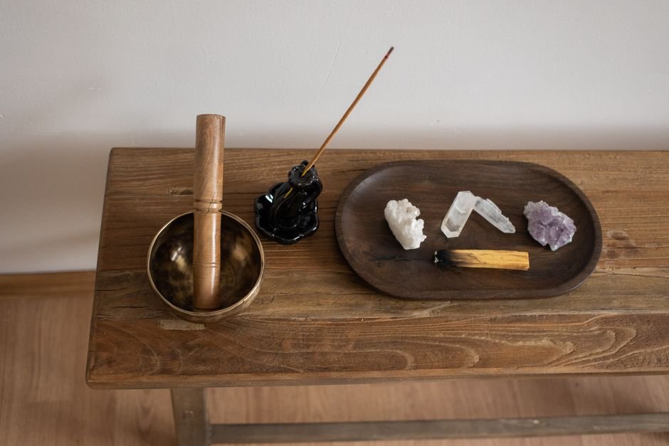 A singing bowl, incense and crystals arranged for a cleansing ritual without sunlight