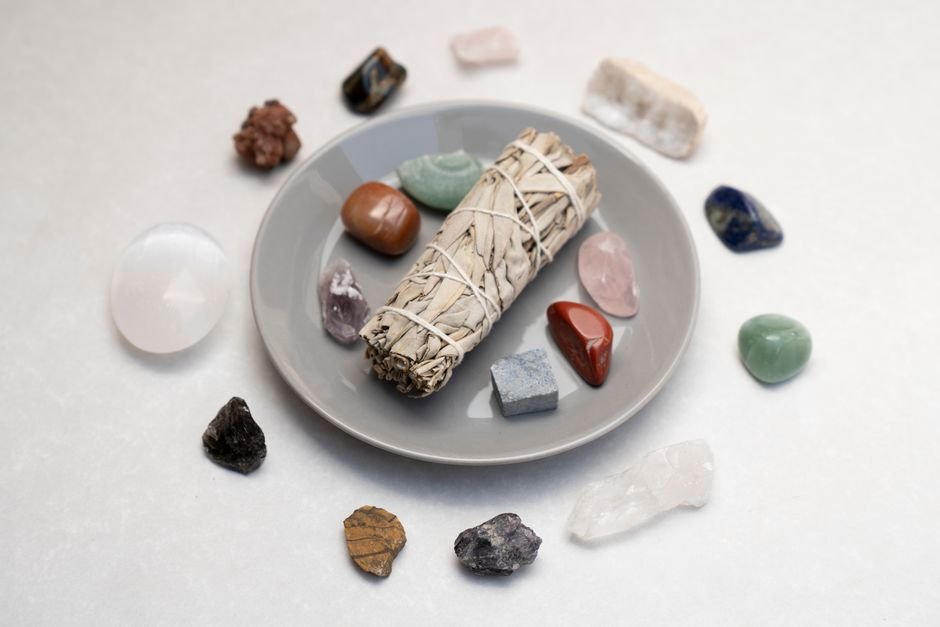 Sage smudge stick and healing crystals arranged on a ceramic plate, a dry cleansing method safe for gypsum
